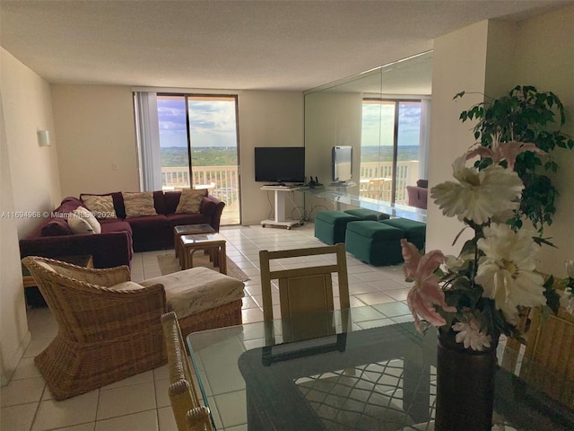 living room featuring floor to ceiling windows, light tile patterned flooring, and a textured ceiling