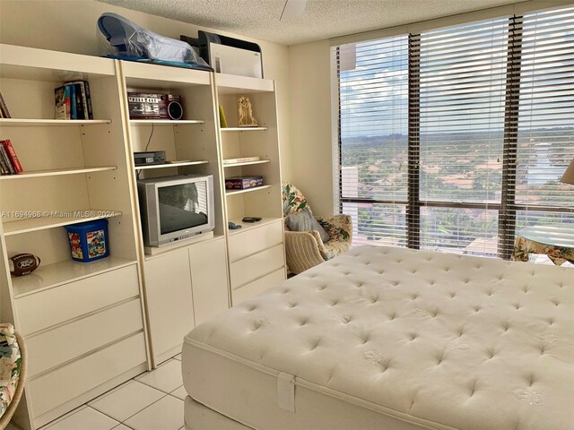 bedroom featuring light tile patterned floors and a textured ceiling