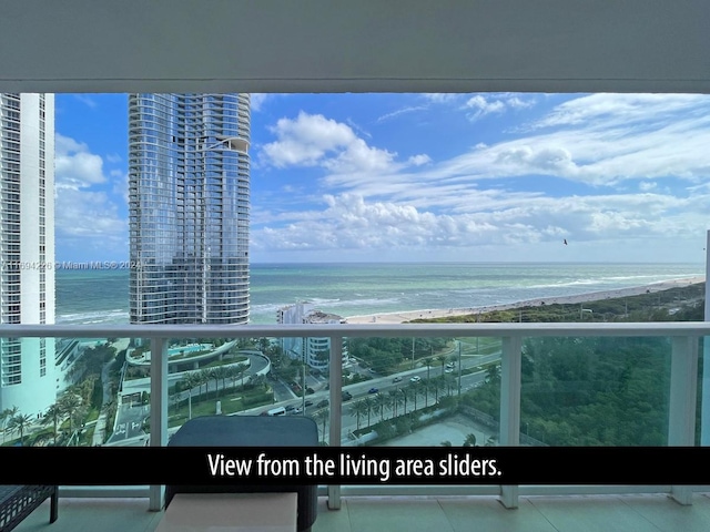 balcony featuring a view of the beach and a water view