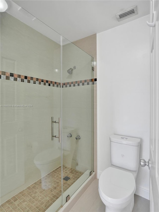 bathroom featuring toilet, tile patterned flooring, and walk in shower