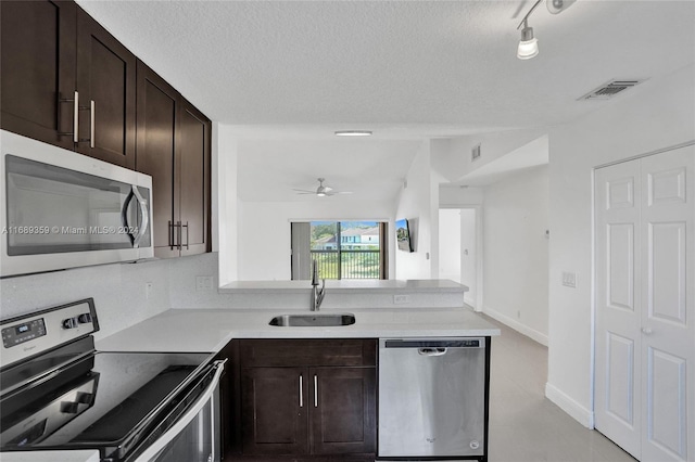 kitchen featuring sink, ceiling fan, a textured ceiling, appliances with stainless steel finishes, and dark brown cabinets