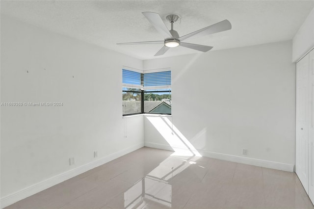 unfurnished room featuring ceiling fan and a textured ceiling