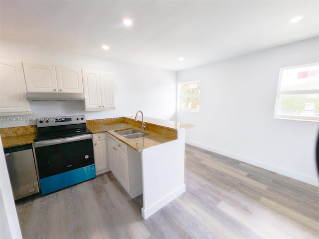 kitchen featuring stainless steel electric stove, kitchen peninsula, plenty of natural light, and white cabinets