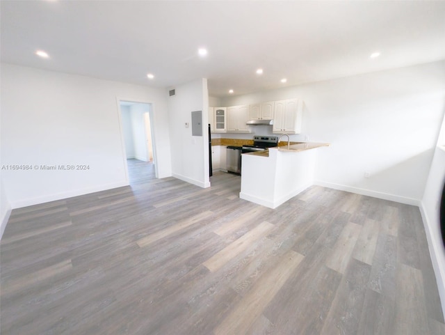 kitchen with kitchen peninsula, wood-type flooring, white cabinets, electric panel, and stainless steel range with electric cooktop