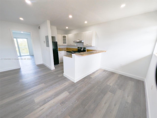 kitchen featuring stainless steel electric stove, light wood-type flooring, kitchen peninsula, and white cabinets