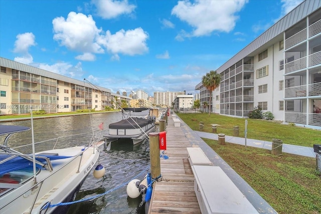 dock area with a water view and a yard