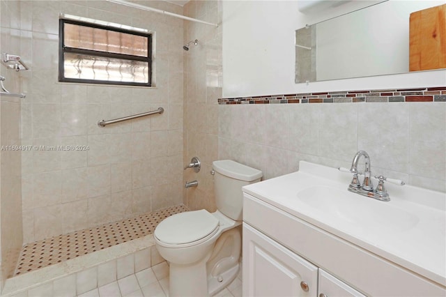 bathroom with tile patterned flooring, vanity, toilet, and tile walls