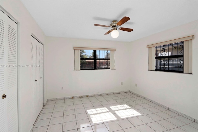 unfurnished bedroom with ceiling fan and light tile patterned floors