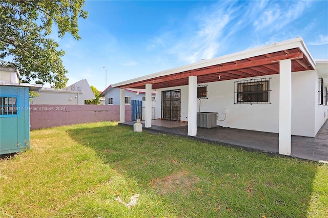 back of house featuring a lawn and cooling unit