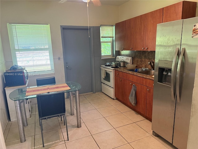 kitchen featuring sink, electric range, decorative backsplash, stainless steel fridge, and light tile patterned floors