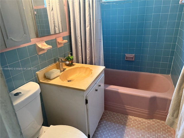 full bathroom featuring vanity, tile patterned flooring, toilet, shower / bath combo with shower curtain, and tile walls