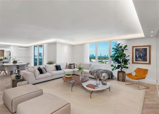 living room with an AC wall unit and light wood-type flooring