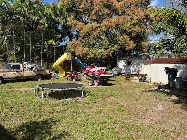 view of yard with a playground, a trampoline, and a storage unit