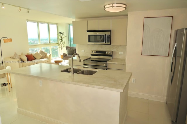 kitchen with sink, light tile patterned floors, stainless steel appliances, and tasteful backsplash