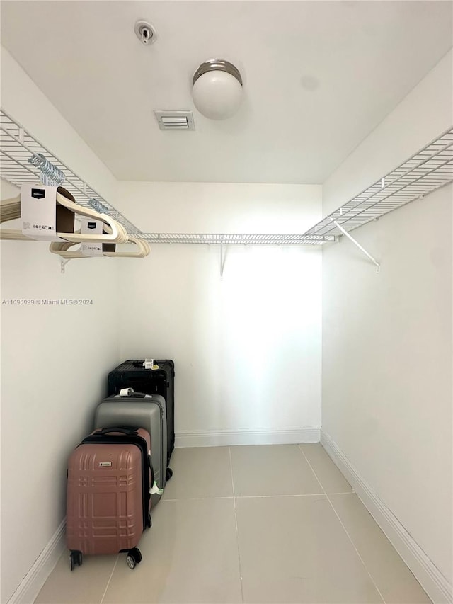 walk in closet with light tile patterned floors