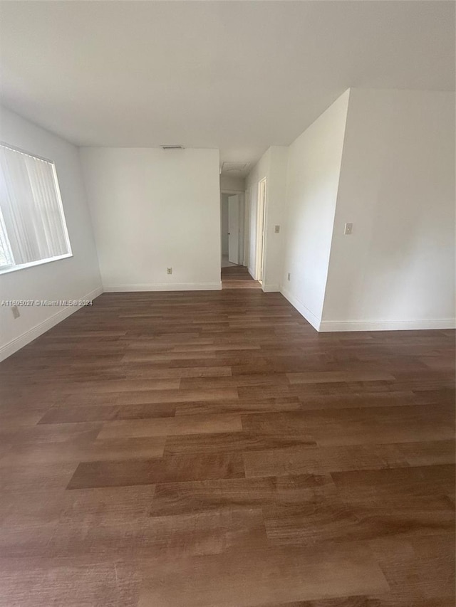 empty room with dark wood-type flooring