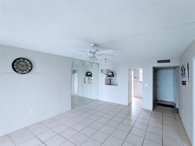 tiled empty room with a textured ceiling and ceiling fan