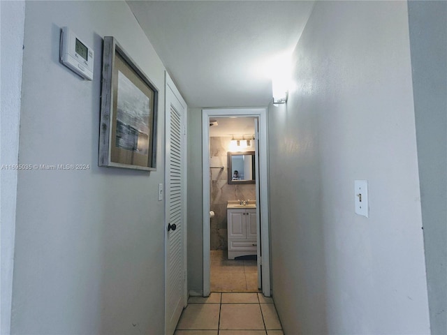 hallway featuring sink and light tile patterned floors