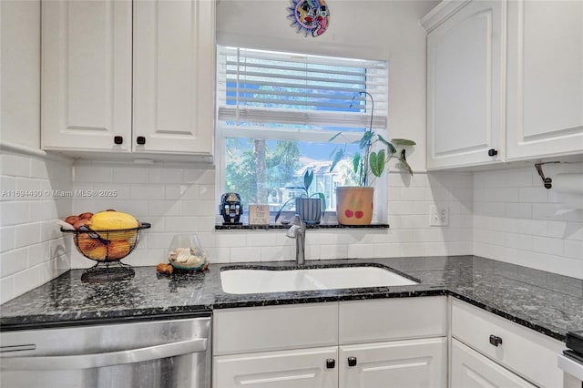 kitchen with sink, white cabinetry, backsplash, stainless steel dishwasher, and dark stone counters