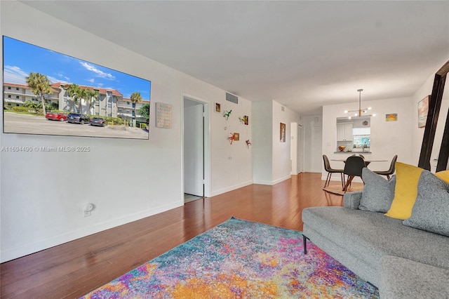 living room with a notable chandelier and wood-type flooring