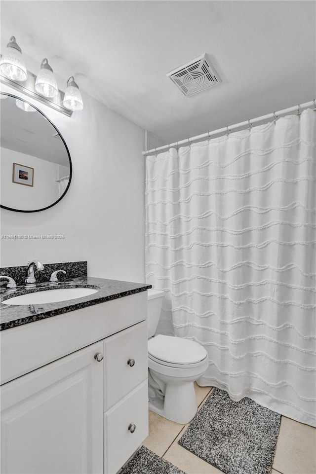 bathroom featuring vanity, tile patterned floors, and toilet