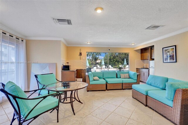 living room with ornamental molding, a textured ceiling, and light tile patterned floors