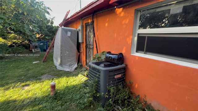 view of property exterior with a yard and central AC unit