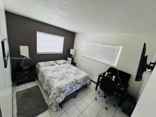 tiled bedroom featuring a textured ceiling