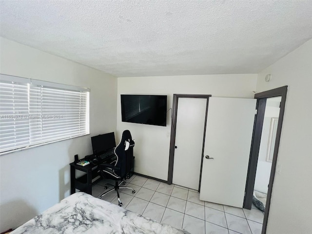 tiled bedroom with a textured ceiling