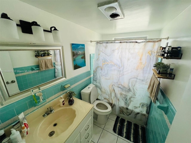 bathroom with tile patterned flooring, vanity, tile walls, and toilet