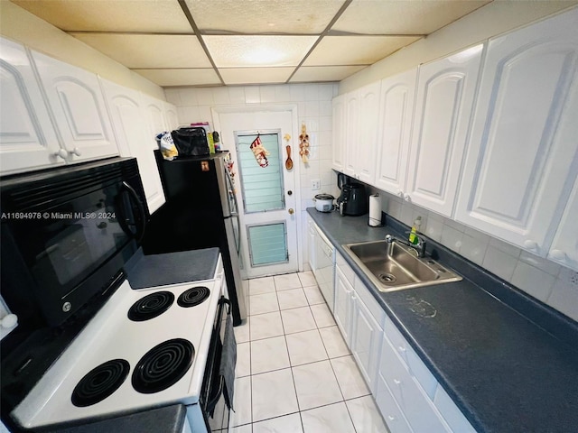 kitchen with a drop ceiling, white appliances, sink, light tile patterned floors, and white cabinetry