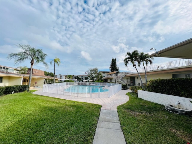 view of swimming pool featuring a lawn and a patio area