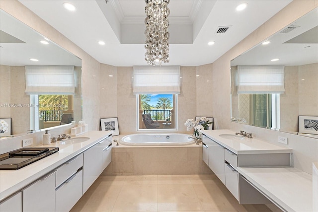 bathroom featuring vanity, a notable chandelier, crown molding, and tiled tub