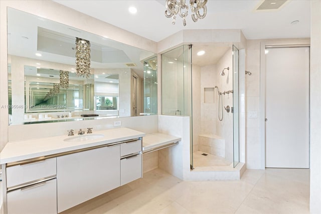 bathroom featuring tile patterned flooring, vanity, a chandelier, and a shower with shower door