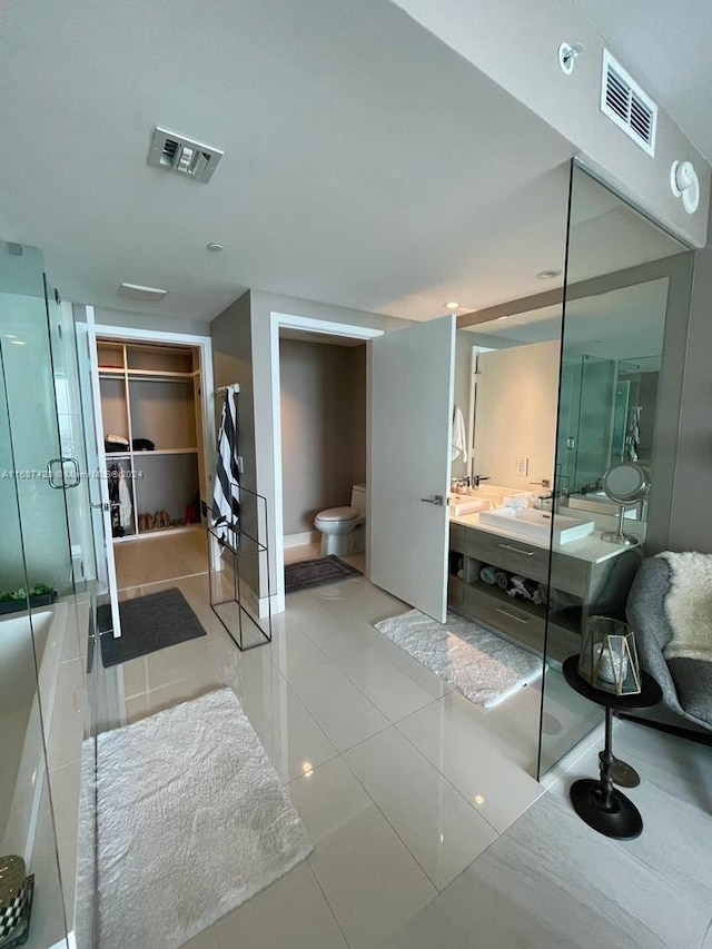 bathroom with tile patterned flooring, vanity, toilet, and a shower with shower door