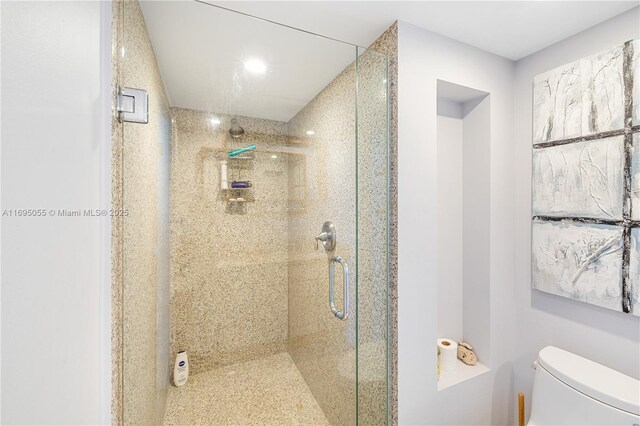 bathroom with toilet and a shower with shower door