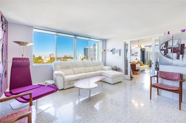 living area with baseboards, a city view, and speckled floor