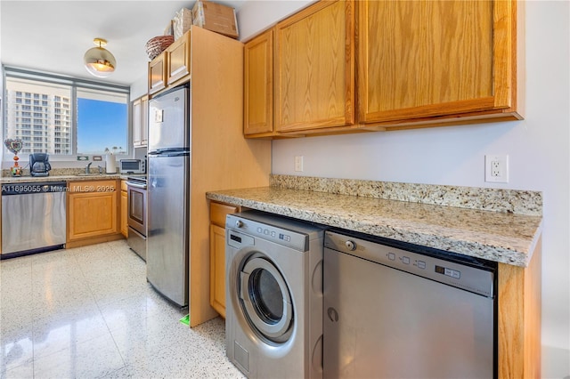 524 Orton Ave Unit 603, Fort Lauderdale, FL 33304 - kitchen featuring a sink, light stone countertops, washer / clothes dryer, and appliances with stainless steel finishes