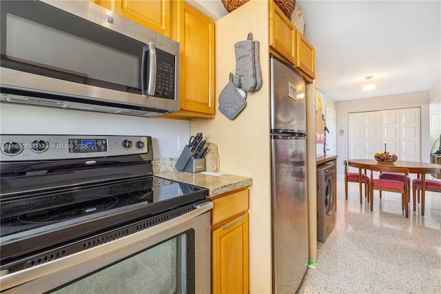 524 Orton Ave Unit 603, Fort Lauderdale, FL 33304 - kitchen featuring light speckled floor, light countertops, washer / clothes dryer, and appliances with stainless steel finishes