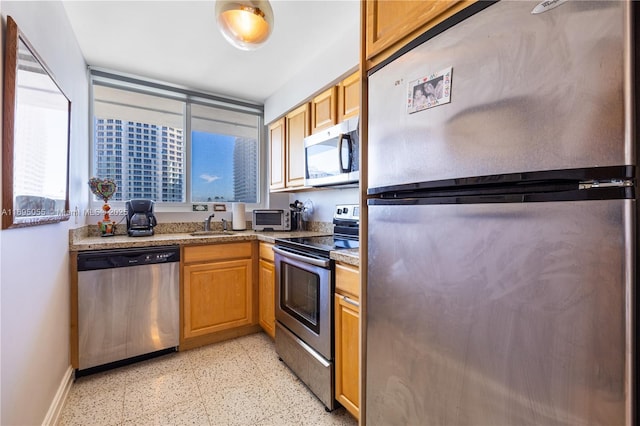524 Orton Ave Unit 603, Fort Lauderdale, FL 33304 - kitchen with baseboards, a wealth of natural light, a sink, and appliances with stainless steel finishes