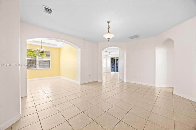 empty room featuring light tile patterned flooring, baseboards, and visible vents