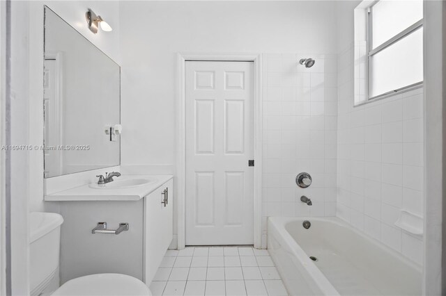 bathroom featuring toilet, vanity, tile patterned flooring, and washtub / shower combination