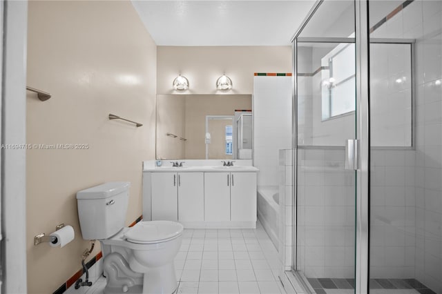 full bathroom featuring double vanity, a tile shower, toilet, tile patterned floors, and a sink