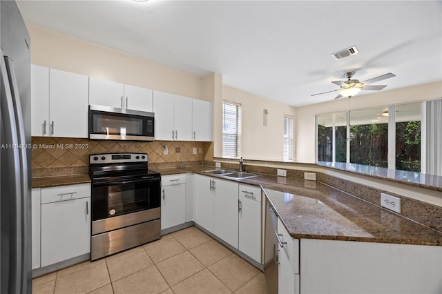 kitchen with white cabinetry, stainless steel appliances, backsplash, a sink, and visible vents