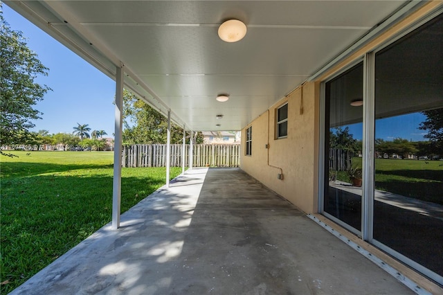 view of patio featuring an attached carport and fence