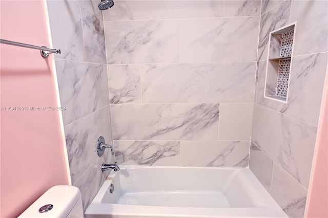 bathroom with tiled shower / bath combo and toilet