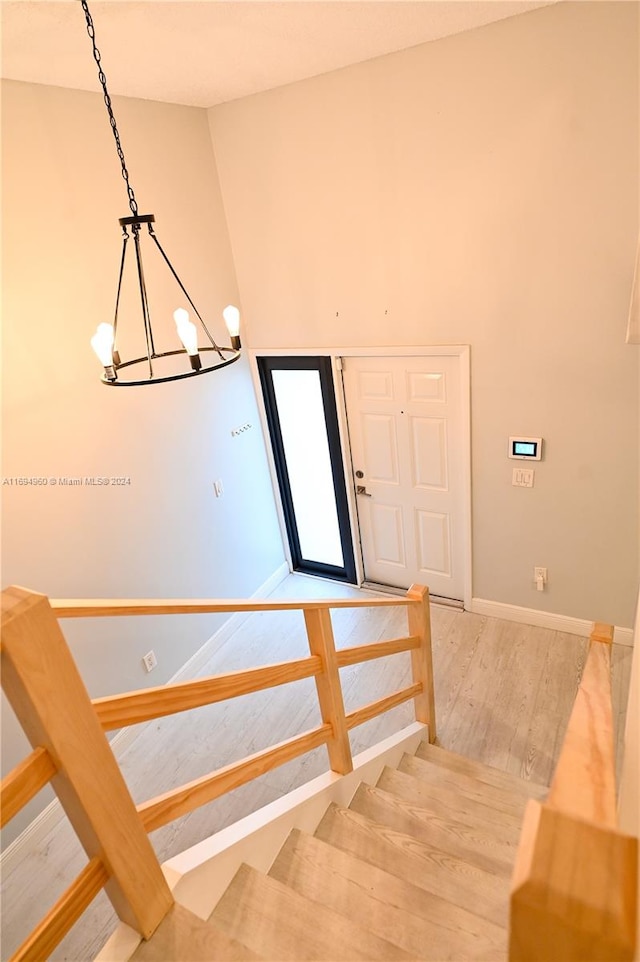 staircase with a notable chandelier and hardwood / wood-style flooring