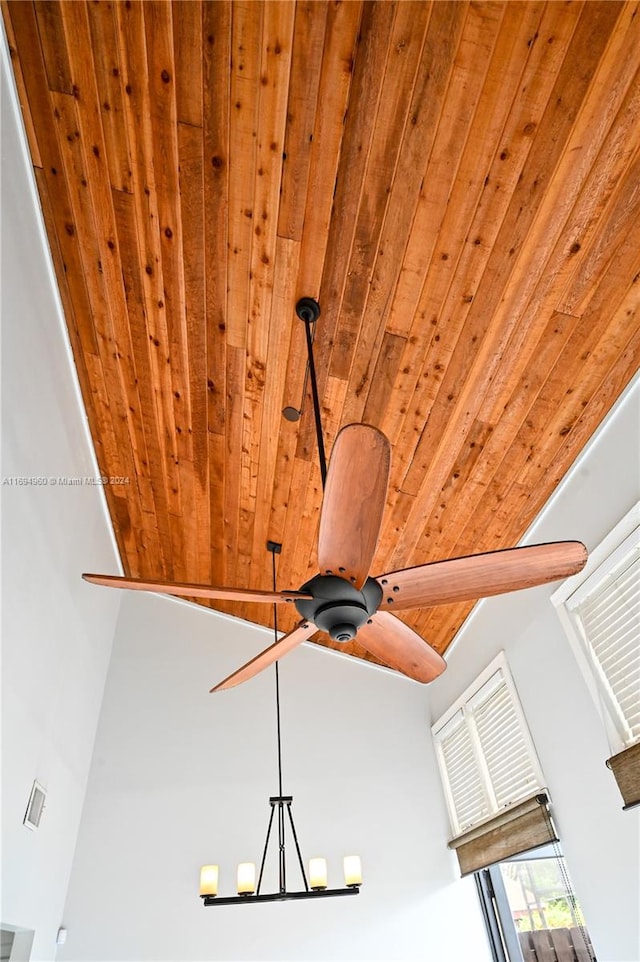 room details featuring wooden ceiling and ceiling fan with notable chandelier