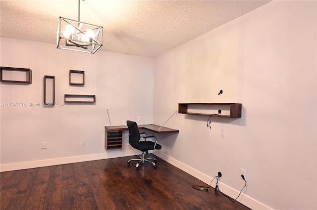 unfurnished office featuring a chandelier, wood-type flooring, a textured ceiling, and built in desk