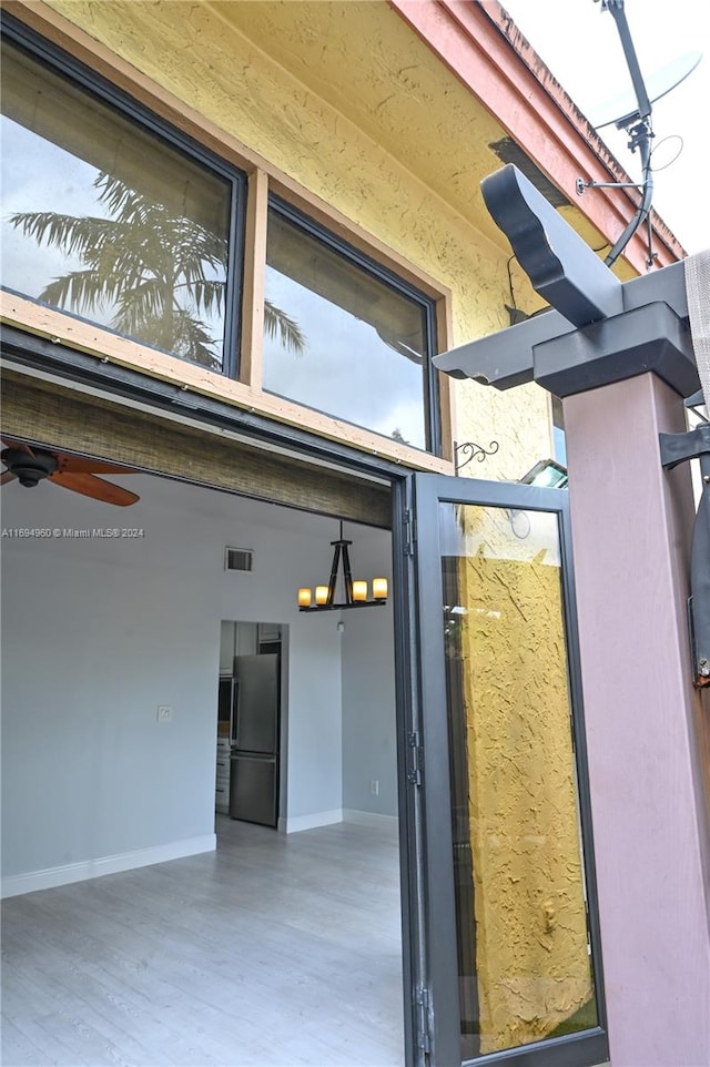 view of exterior entry featuring ceiling fan